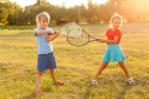 two little girls with tennis rackets photo