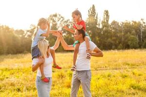 young familiy running through a yellow field photo