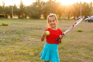 Nice girl with racket in hands playing game of tennis photo