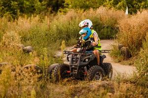 little boy with instructor on a quad bike photo