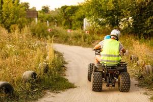 little boy with instructor on a quad bike photo