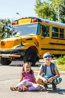 riendo sonriente niño caucásico estudiante niño con expresión de cara divertida caminando cerca del autobús amarillo el 1 de septiembre. educación y concepto de regreso a la escuela. niño alumno listo para aprender y estudiar. foto