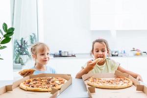 Two little girls eating pizza photo