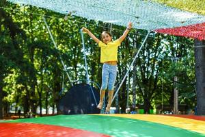 Little child jumping on big trampoline - outdoor in backyard photo