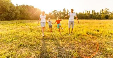 joven familia feliz con dos hijos en el parque de verano foto