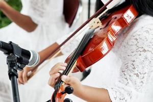 picture of young asian girl is playing the violin, close up photo