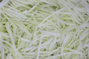 Shredded raw mango prepared for cooking in the kitchen for background. photo