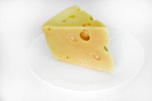 A large piece of cheese on a white background. A triangular piece of cheese with holes. photo