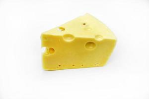 A large piece of cheese on a white background. A triangular piece of cheese with holes. photo