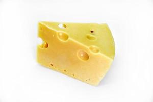 A large piece of cheese on a white background. A triangular piece of cheese with holes. photo