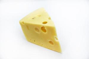 A large piece of cheese on a white background. A triangular piece of cheese with holes. photo