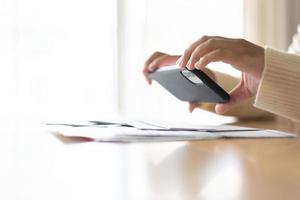 Woman paying bills using mobile phone. Cashless payment concept. photo