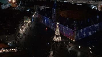 noche de navidad aérea del casco antiguo de varsovia. hermoso árbol de navidad iluminado en medio de la ciudad. video