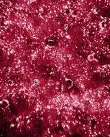 Closeup branches of coniferous tree decorated with glittering balls and shiny light garland on Christmas day at home. Color Of The Year 2023 - Viva Magenta photo