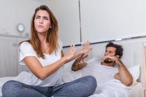 Couple With Problems Having Disagreement In Bed. Frustrated couple arguing and having marriage problems, Young couple into an argument on bed in bedroom photo