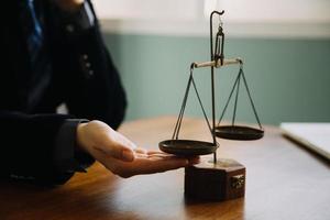 Business and lawyers discussing contract papers with brass scale on desk in office. Law, legal services, advice, justice and law concept picture with film grain effect photo