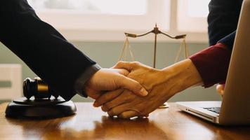 Business and lawyers discussing contract papers with brass scale on desk in office. Law, legal services, advice, justice and law concept picture with film grain effect photo