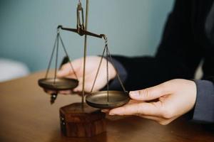 Business and lawyers discussing contract papers with brass scale on desk in office. Law, legal services, advice, justice and law concept picture with film grain effect photo