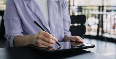 colegas asiáticos hombre y mujer discutiendo y trabajando con una computadora portátil en el escritorio de la oficina foto