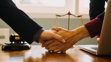 Business and lawyers discussing contract papers with brass scale on desk in office. Law, legal services, advice, justice and law concept picture with film grain effect photo