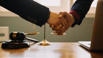 Business and lawyers discussing contract papers with brass scale on desk in office. Law, legal services, advice, justice and law concept picture with film grain effect photo