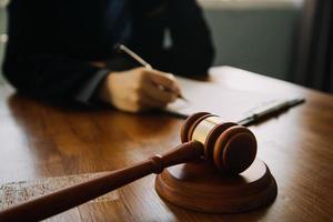 Business and lawyers discussing contract papers with brass scale on desk in office. Law, legal services, advice, justice and law concept picture with film grain effect photo