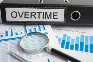 Overtime. Binder data finance report business with graph analysis in office. photo