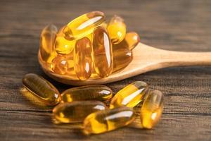 Fish oil Omega 3 capsules vitamin with EPA and DHA isolated on wooden background. photo