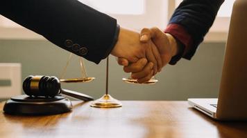 Business and lawyers discussing contract papers with brass scale on desk in office. Law, legal services, advice, justice and law concept picture with film grain effect photo