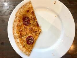 tres rebanadas de pizza en un plato blanco foto