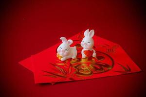 Chinese New Year of the rabbit festival concept. Rabbit on red envelopes isolated on red background. Happy New Year Chinese Rabbit 2023. photo