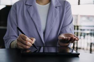 colegas asiáticos hombre y mujer discutiendo y trabajando con una computadora portátil en el escritorio de la oficina foto