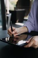 colegas asiáticos hombre y mujer discutiendo y trabajando con una computadora portátil en el escritorio de la oficina foto