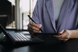 colegas asiáticos hombre y mujer discutiendo y trabajando con una computadora portátil en el escritorio de la oficina foto