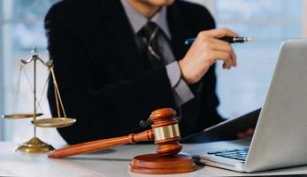 Business and lawyers discussing contract papers with brass scale on desk in office. Law, legal services, advice, justice and law concept photo