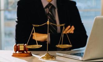 Business and lawyers discussing contract papers with brass scale on desk in office. Law, legal services, advice, justice and law concept photo