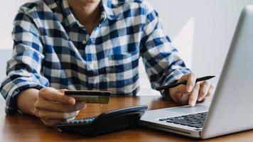 Hands holding credit card and using laptop. Online shopping photo