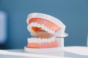 Stomatology concept, partial portrait of girl with strong white teeth looking at camera and smiling, fingers near face. Closeup of young woman at dentist's, studio, indoors photo