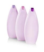 botellas de plástico rosa con capas de colores de cuidado corporal y productos de belleza. Fotografía de estudio de botella de plástico para champú - aislado sobre fondo blanco. foto