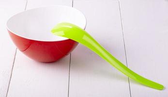 green plastic spoon salad on white wooden table photo