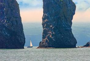 velero navega cerca de la costa y las rocas en la península de kamchatka