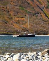 yacht on the bay of Pacific ocean in Kamchatka peninsula with mountains on background photo