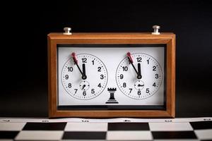 classic, mechanical chess clock on wooden chess board. Selective focus photo