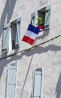 facade of the building with the flags of France in the window. photo