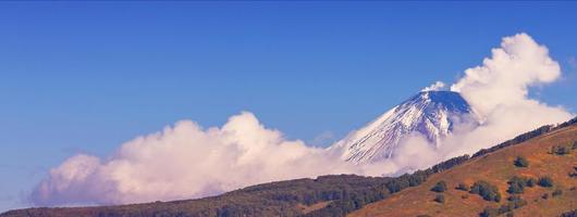 Panoramic view of snow volcano and blue sky photo