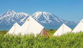 Glamping house and volcano, rural landscape, tent houses in Kamchatka peninsula. Selective focus. photo