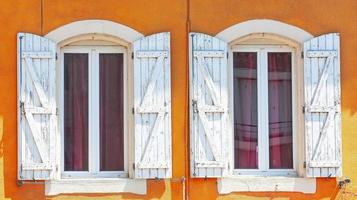 Detail of an open wooden vintage rustic windows on red cement old wall can be used for background photo