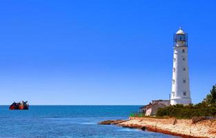 Lovely white lighthouse on the coast of the Black sea photo