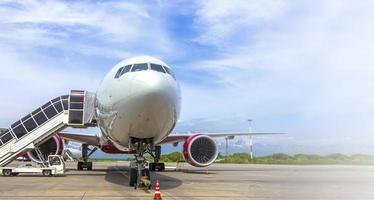 avión con pasos de embarque de pasajeros en la plataforma del aeropuerto foto