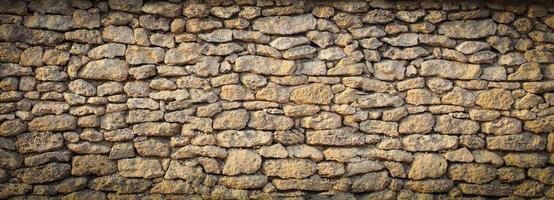 old solid wall of rough stones in Europe photo